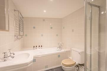 The super stylish family bathroom has a bath and enclosed shower.