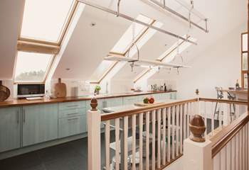 The kitchen is full of light thanks to all the glass and windows. The stairs take you down to the ground floor. 