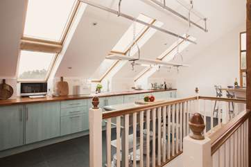 The kitchen is full of light thanks to all the glass and windows. The stairs take you down to the ground floor.