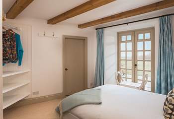 Pretty bedroom 3 has a double bed and enjoys views across the lawn. Whilst the patio doors do not open, the windows at the top of the doors can be opened to let in a gentle breeze. The door leads into the utility-room. 