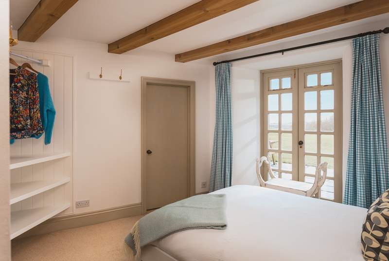 Pretty bedroom 3 has a double bed and enjoys views across the lawn. Whilst the patio doors do not open, the windows at the top of the doors can be opened to let in a gentle breeze. The door leads into the utility-room. 