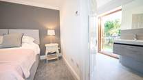 The sumptuous main bedroom on the second floor with en suite bathroom leading out to a balcony.