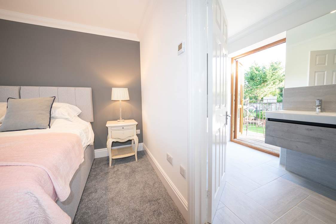 The sumptuous main bedroom on the second floor with en suite bathroom leading out to a balcony.