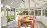 The conservatory at Saye House with access to the garden and steps up to the outdoor dining area. - Thumbnail Image