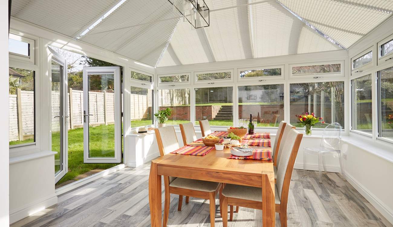 Open the doors to the garden and follow the steps up to the outdoor dining-area.