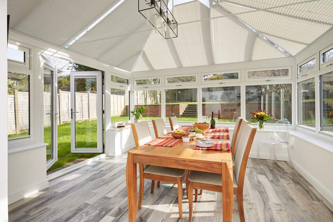Open the doors to the garden and follow the steps up to the outdoor dining-area.