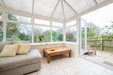 Appreciate the light and airy conservatory leading out to the garden.