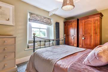 The main bedroom floods with lights and offers a glimpse of village life and the church spire.