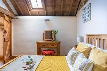 Both bedrooms flood with light thanks to the vaulted ceilings and Velux windows.