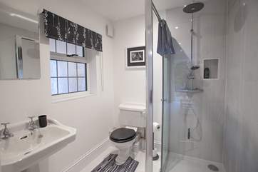 A large modern shower cubicle with a rainfall shower head.