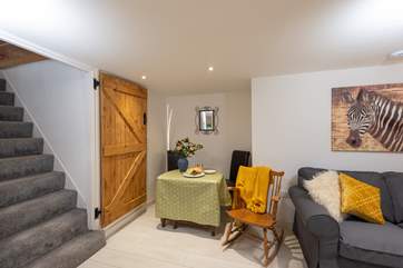 A cosy spot for holiday meals. The stairs lead directly up to the bedroom but the lovely wooden door in view can be closed.