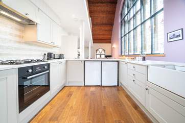 The light from the stained glass windows floods in to the bright and modern kitchen.