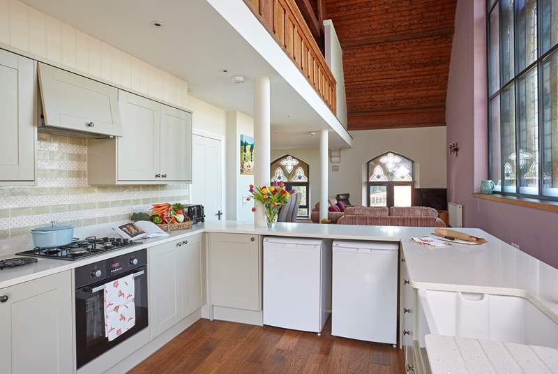 The light from the stained glass windows floods in to the bright and modern kitchen.
