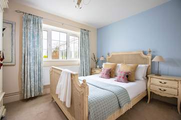 Bedroom 1 sits next to the main bathroom and offers French chic style with views to the back garden and of course the pool.