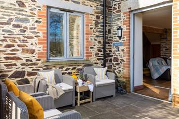 The patio area leads on to a lawned area that is fenced in.