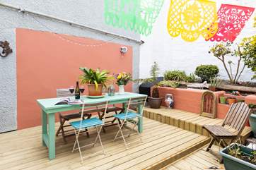 The colourful inner courtyard is decked and tucked away at the rear of the house.
