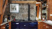 The spacious and well-equipped kitchen. The Aga is ornamental but you do have an induction hob and electric oven for cooking up your holiday meals.
