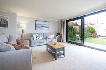 The light and airy sitting-room has doors opening onto the garden.