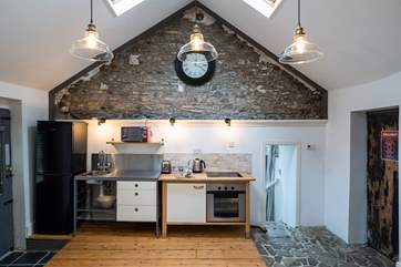 Rustic original uneven stone steps down to the utility-area and shower-room.