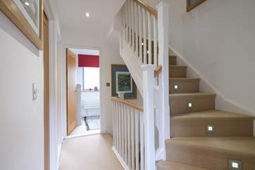 An illuminated stairway to the first floor up to the top floor bedroom.