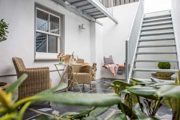 Metal steps lead up from the lower terrace to the communal garden where each apartment has their own private seating area.