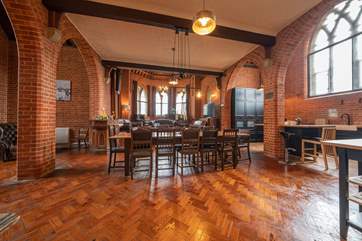 The open plan living-room with dining and kitchen areas flood with light from the stained glass windows.
