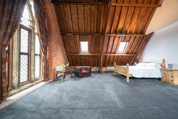 The main bedroom on the first floor. The large windows and original features showcase this spacious room brimming with charm.