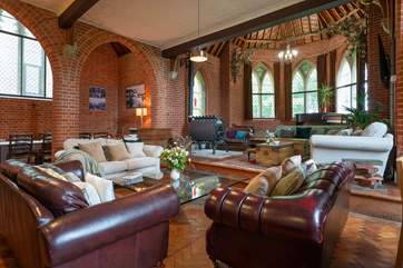 The open plan living-room with dining and kitchen areas flood with light from the stained glass windows.