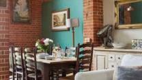 Dine around the grand dining-table situated in the open plan living-room with dining and kitchen areas.