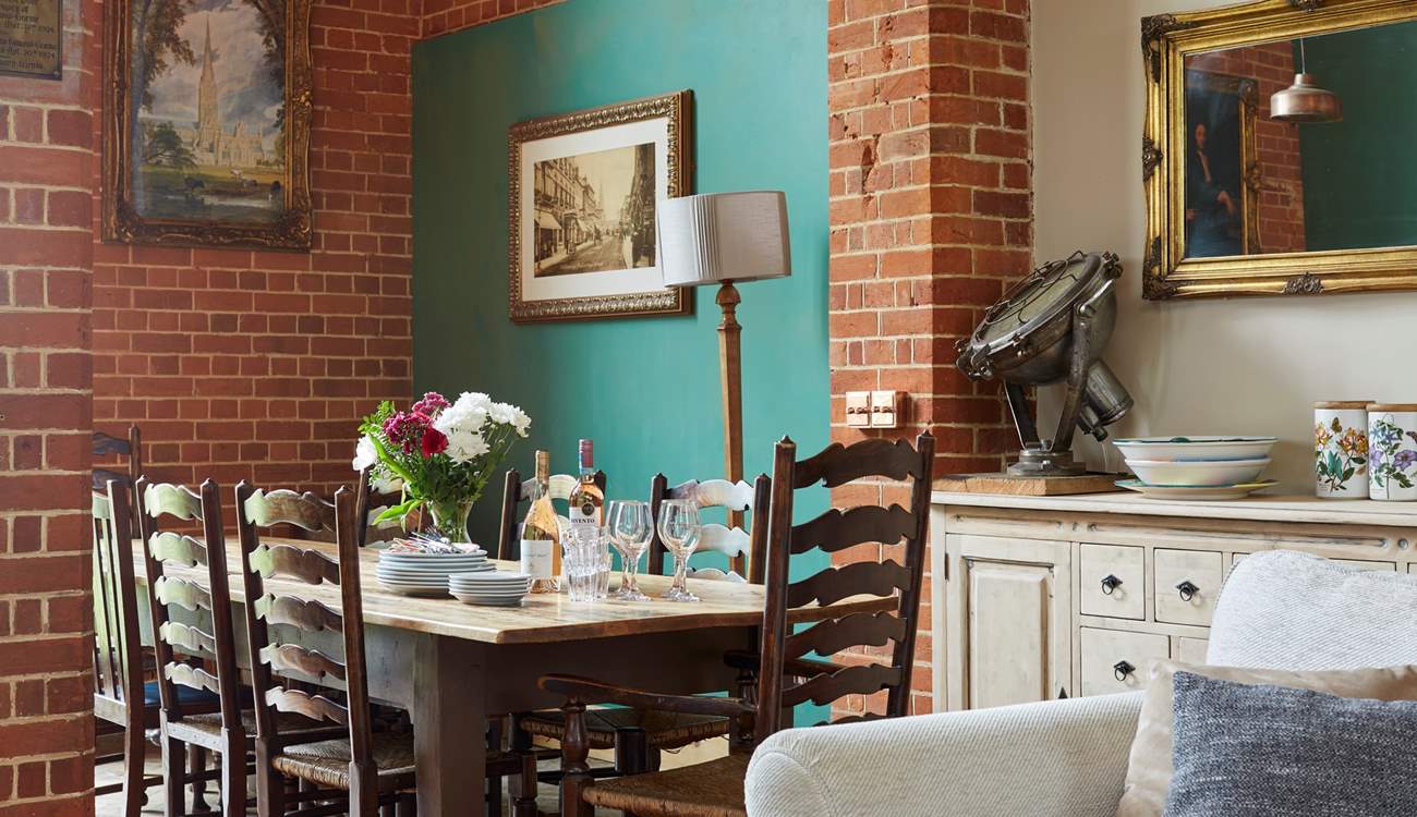 Dine around the grand dining-table situated in the open plan living-room with dining and kitchen areas.