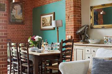 Dine around the grand dining-table situated in the open plan living-room with dining and kitchen areas.