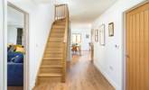 The front door opens to the coast path and inside you can see the open plan living space and sitting-room along with the oak staircase leading to the bedrooms.  - Thumbnail Image