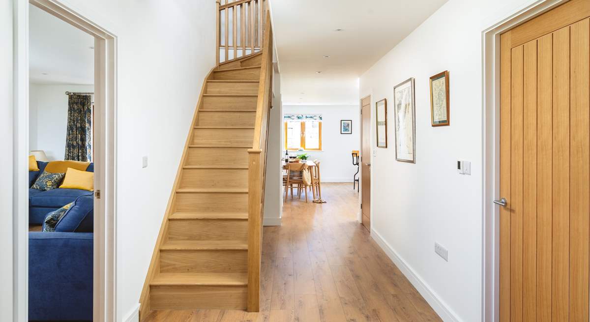 The front door opens to the coast path and inside you can see the open plan living space and sitting-room along with the oak staircase leading to the bedrooms. 