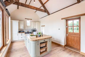 The kitchen island is the perfect place to perch with a drink and chat to the chef.