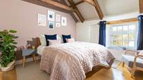 The luxurious main bedroom with characterful exposed beams.