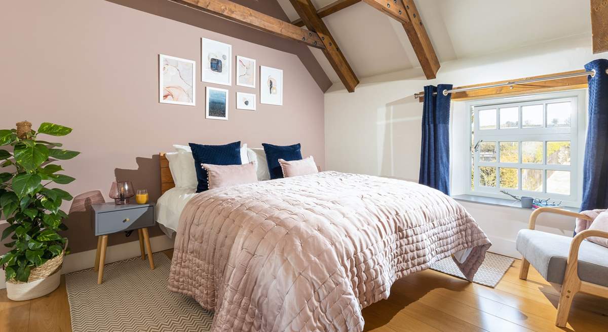 The luxurious main bedroom with characterful exposed beams.