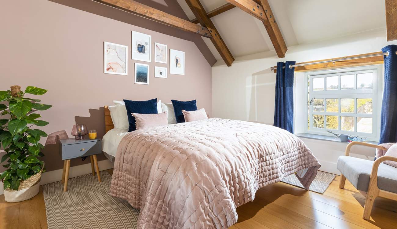 The luxurious main bedroom with characterful exposed beams.