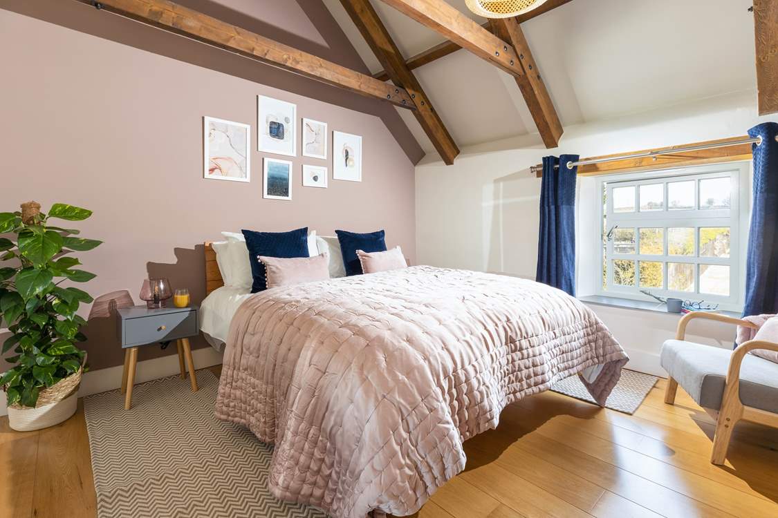 The luxurious main bedroom with characterful exposed beams.