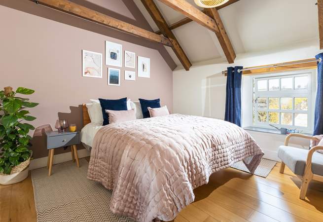The luxurious main bedroom with characterful exposed beams.