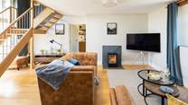 The fabulous sitting-room with floor to ceiling windows is the perfect place to relax.