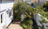 The secluded back garden has a tropical feel with Mediterranean palms and olive trees. - Thumbnail Image