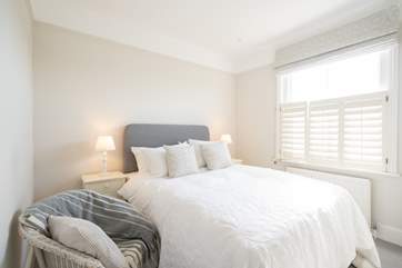 The bright first bedroom overlooks the garden.