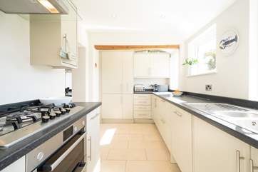 The modern style kitchen overlooks the garden, ideal while you cook up a favourite family meal.