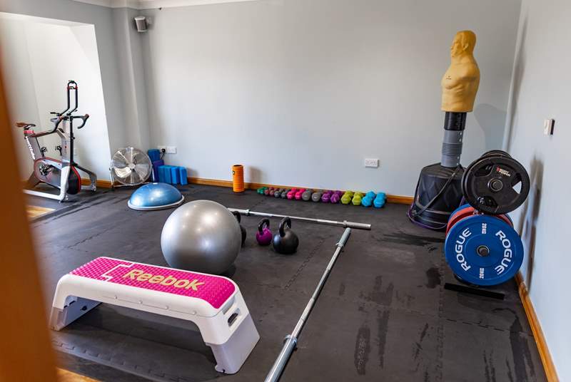 A studio gym including 2021 Watt bike atom, hand weights, Olympic barbell and plates up to 200kg, medicine ball, Bosu, stability balls, foam rollers, step, kettlebells, mobility bands, skipping ropes and yoga mats and blocks. 