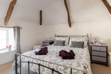 Original beams and a vaulted ceiling adds charm and character to this beautiful bedroom.