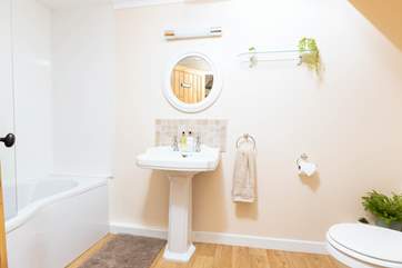 The bathroom is both spacious and well thought out, offering a bath with an electric shower.