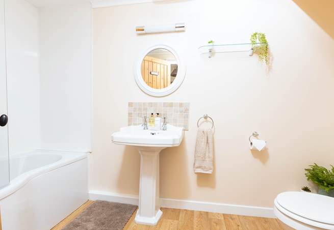 The bathroom is both spacious and well thought out, offering a bath with an electric shower.