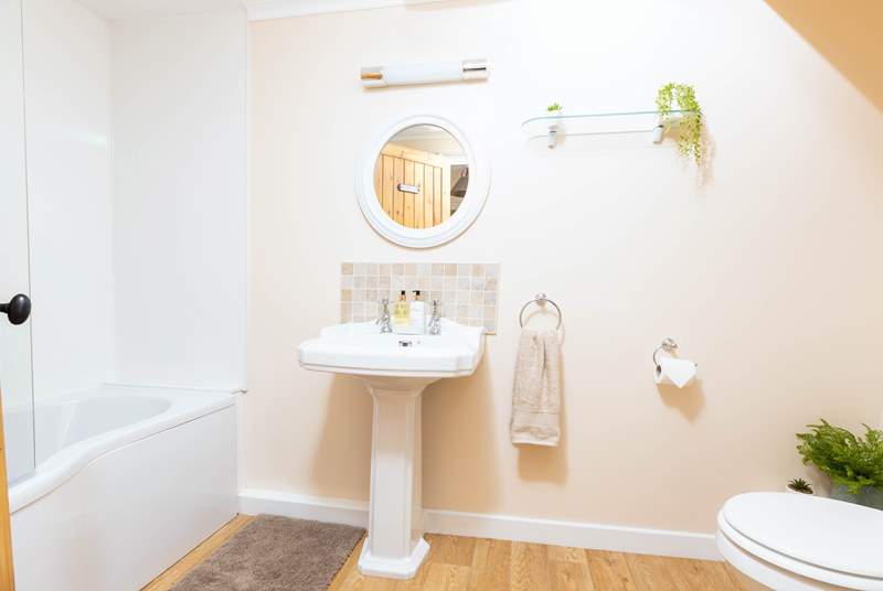The bathroom is both spacious and well thought out, offering a bath with an electric shower.