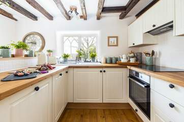 The kitchen is fully equipped and has views out across the treetops and down the valley.