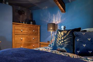 Lovely linens, velvet cushions and a sumptuous throw adorn the bed.